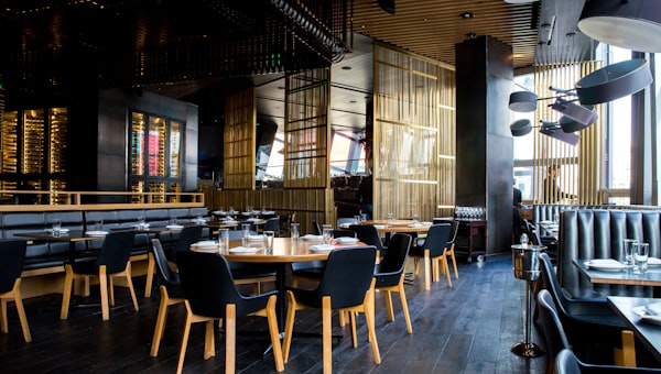 Interior de restaurante moderno com mesas postas e iluminação ambiente quente — exemplo de site para restauração